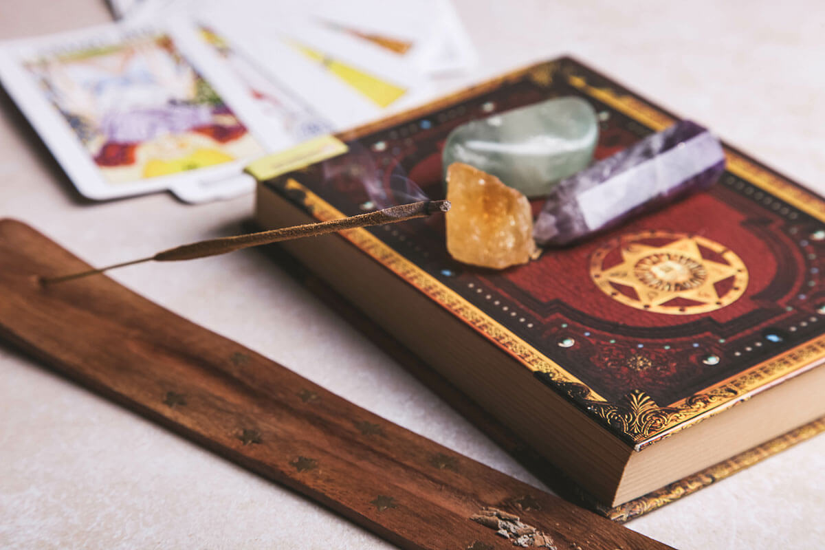 Toast wellness trend forecasts for 2021 include the rise of modern mystics, and this image shows crystals, incense, tarot cards and a book.