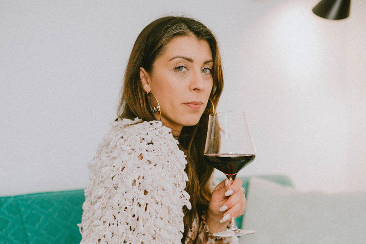 Samantha Rae from Metro Liquor Stores drinking a glass of red, one of the top wines under $25