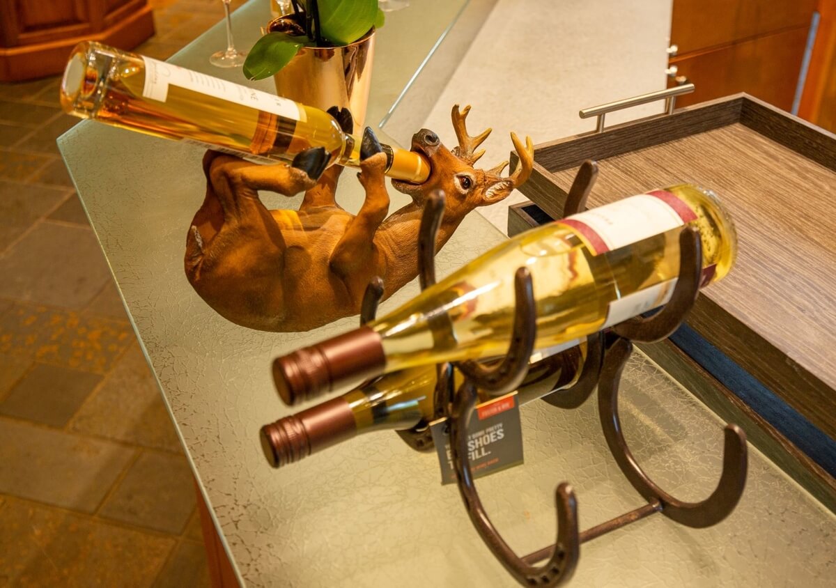 small upside down wooden moose , with a bottle of icewine fruit of the frozen vine in its mouth