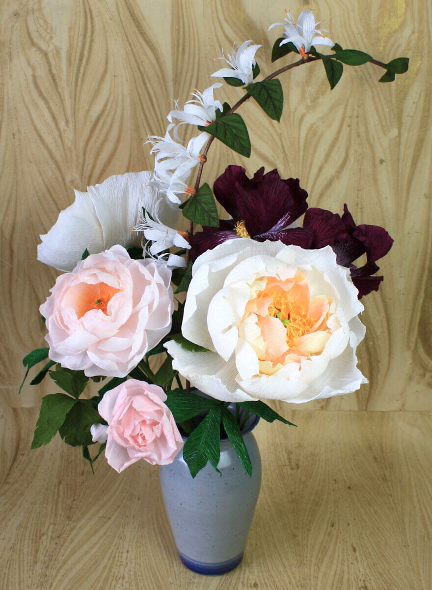 A bouquet of pink and peach flowers, made from recycled materials
