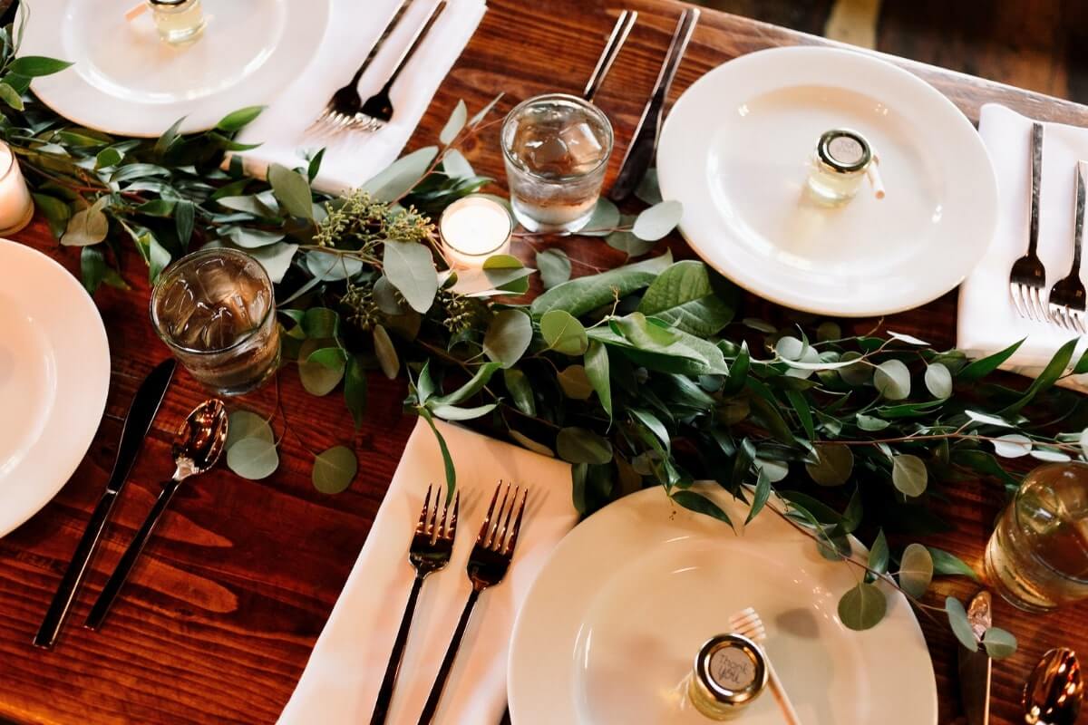 a set table with greenery, past of a sustainable COVID wedding