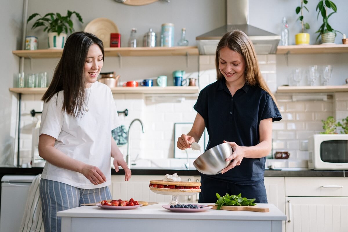 Two young women cooking a flan at a kitchen counter