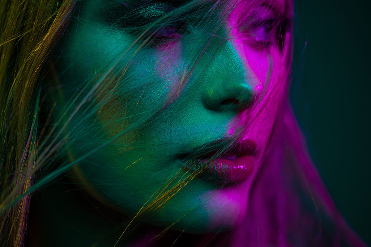 model's face with blue, green and magenta light