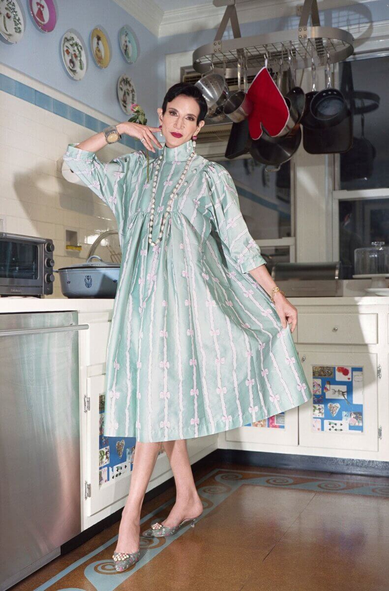 Model in a kitchen wearing a light green & pink flowing knee-length dress, by Batsheva RTW Fall 2021 fashion collections