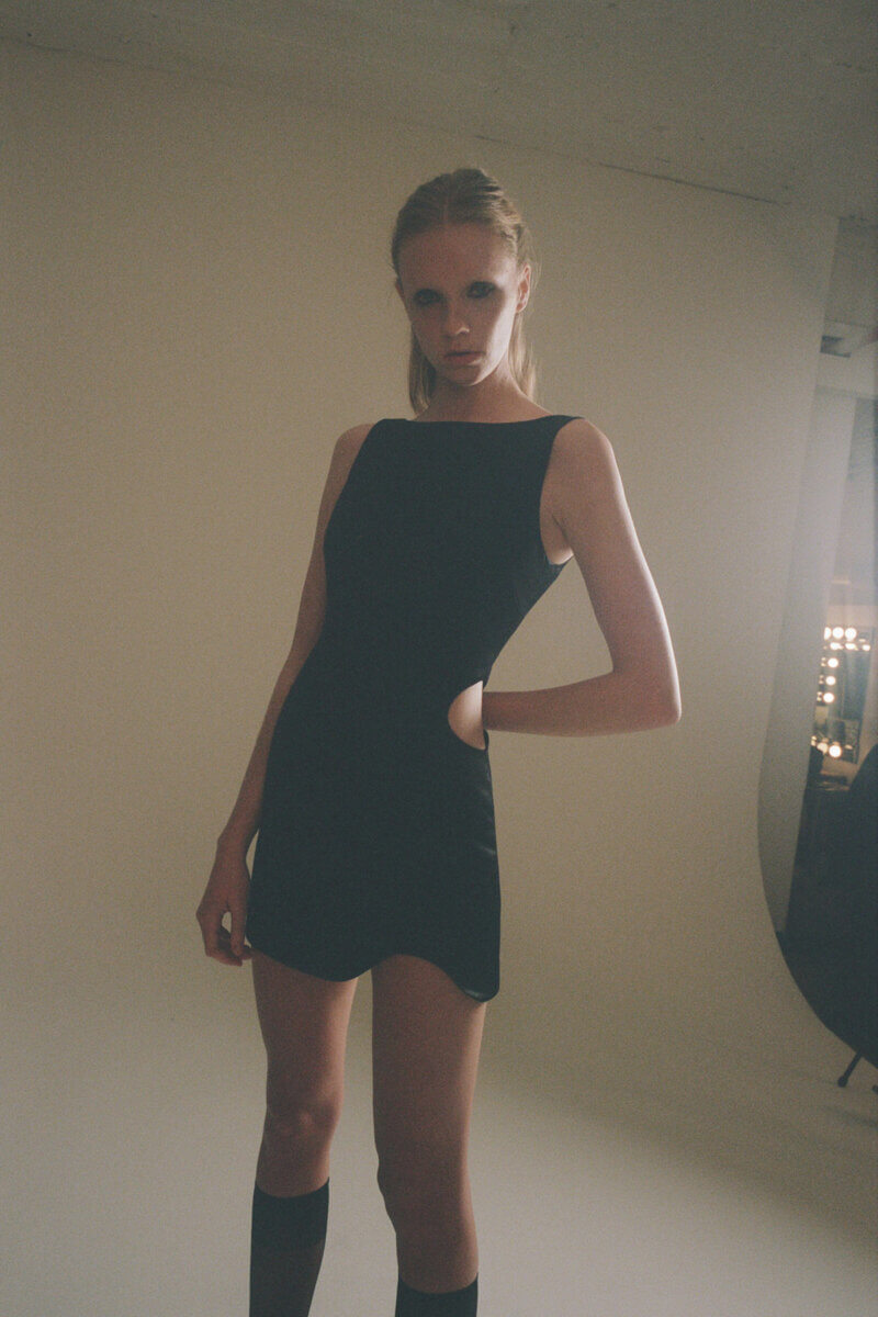 Standing model in short black dress by Sandy Liang RTW