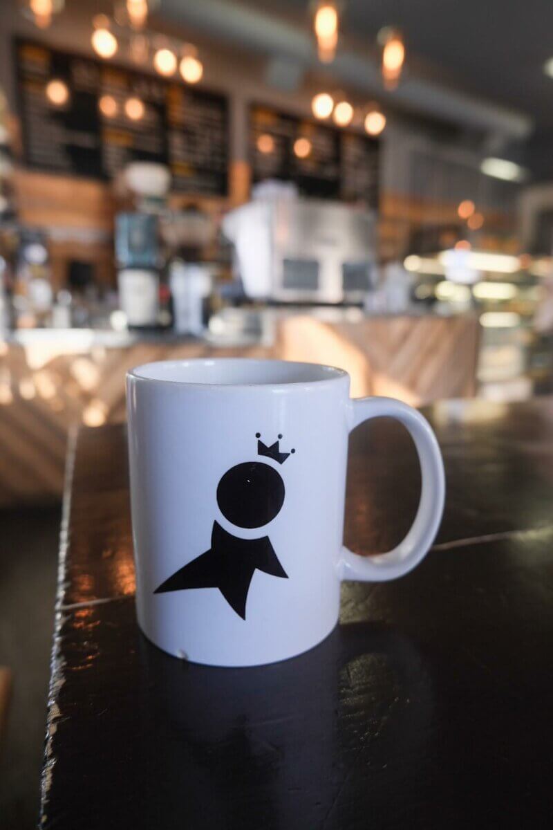 white coffee mug with black design at Citizen Cafe and Bakery, one of Toast's March activities in Saskatoon