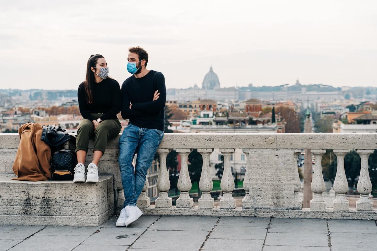 A man and woman resting on a bridge in a historic city