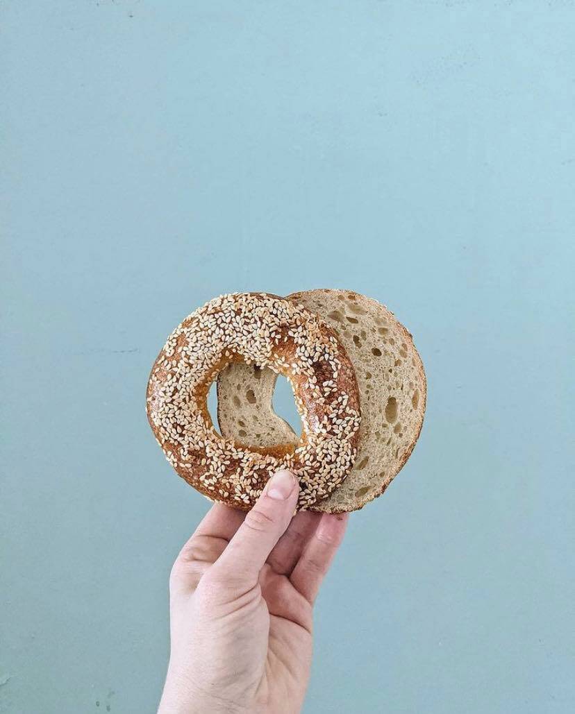 hand holding bagel from Happy Hi Coffee & Bakery, part of Regina March Event Guide