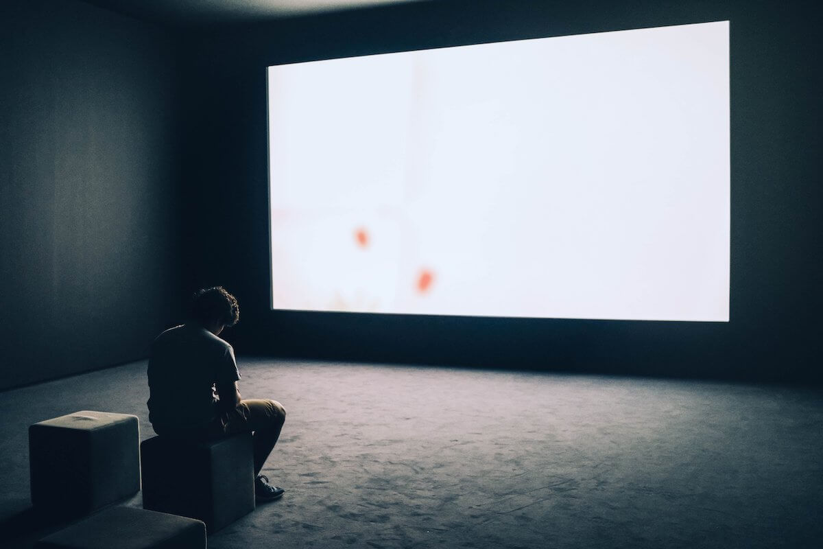 man sitting in small makeshift cinema in a Canadian art institution