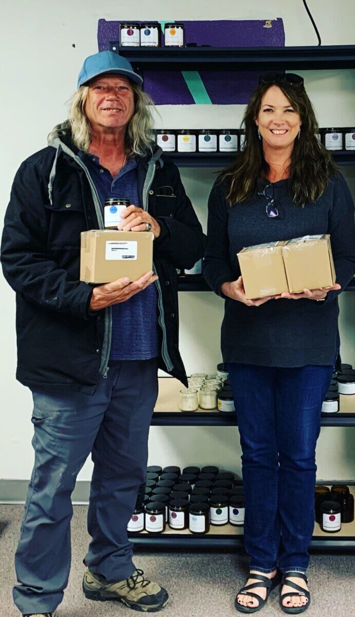 man and woman holding boxes of handmade candles, part of All in ADays Work program