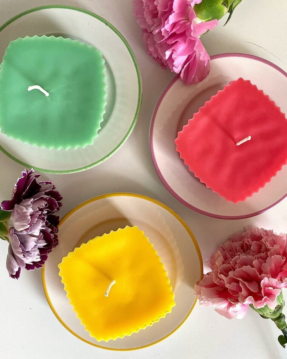 green, yellow & pink candles on white circular plates