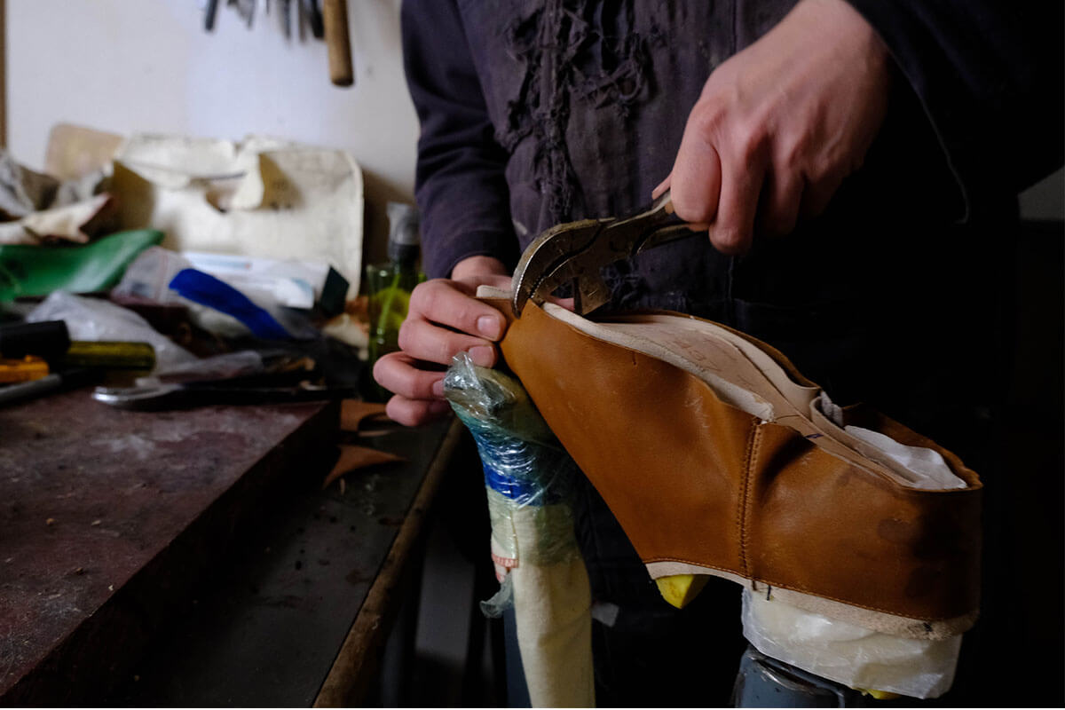 Adam Finn stretching the leather over the last of a pair of custom made shoes