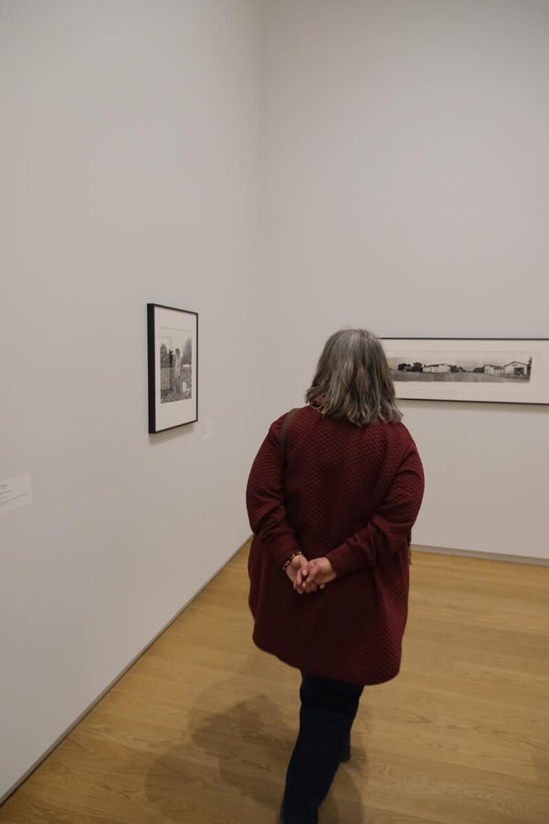 woman touring a back and white photo exhibit, explore Saskatoon in April