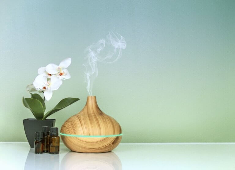 diffuser beside a white flower keeping fresh air in small spaces