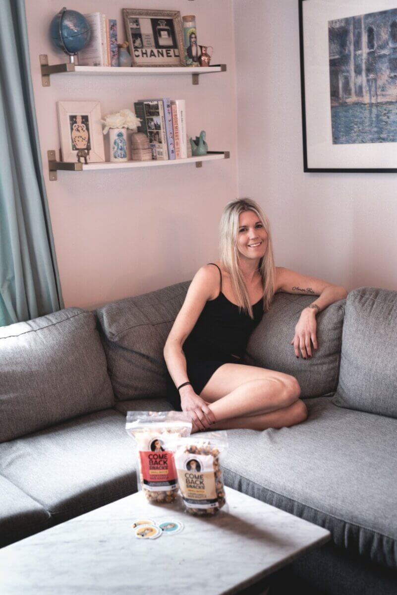 Emily O’Brien on her couch, founder of Comeback Snacks, popcorn with a mission