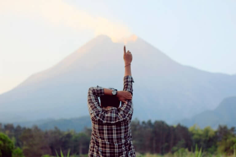 a man holding his hand up facing a mountain, the secret to unlimited possibilities