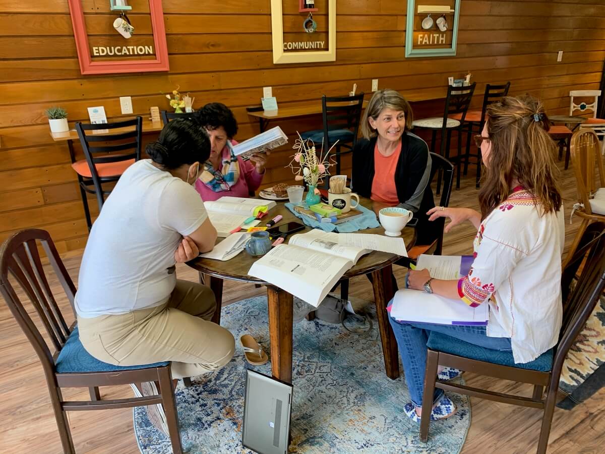 4 people working at a table in a coffee shop