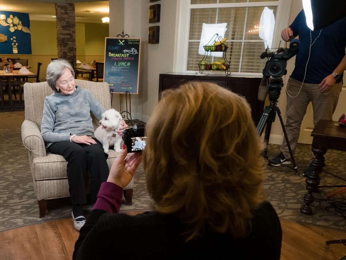 doggies for dementia taking photos of an elderly woman with her small white dog