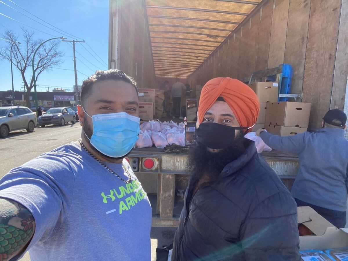 Volunteers loading food onto a large truck for Guru Nanak Free Kitchen 