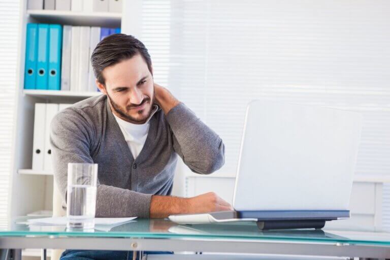 man working at desk with sore neck needing massage tools