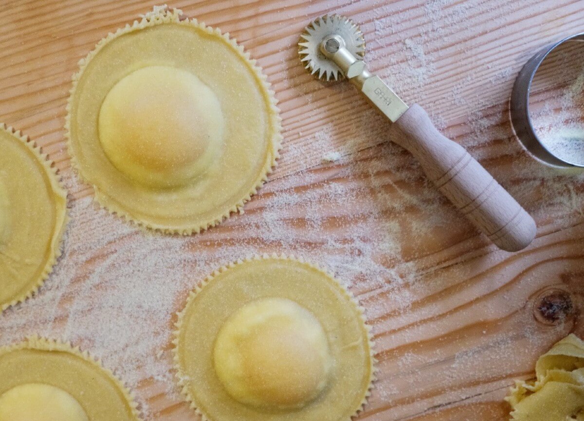fresh pasta on a floured board with the edges cut by a pasta wheel