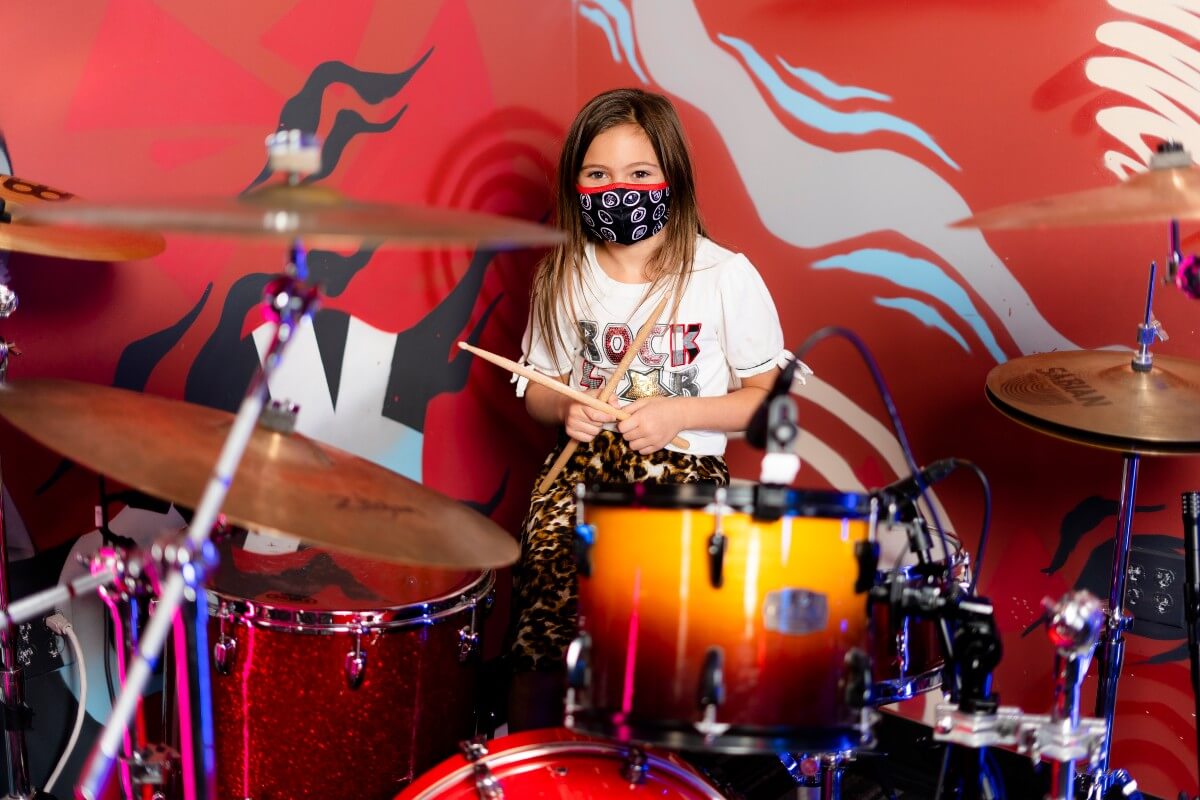 young girl playing drums at regina's school of rock
