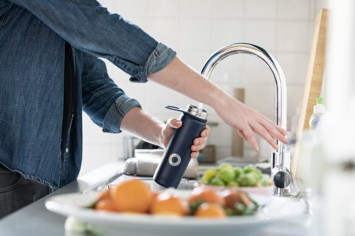 person filling a resuable water bottle to help save the oceans