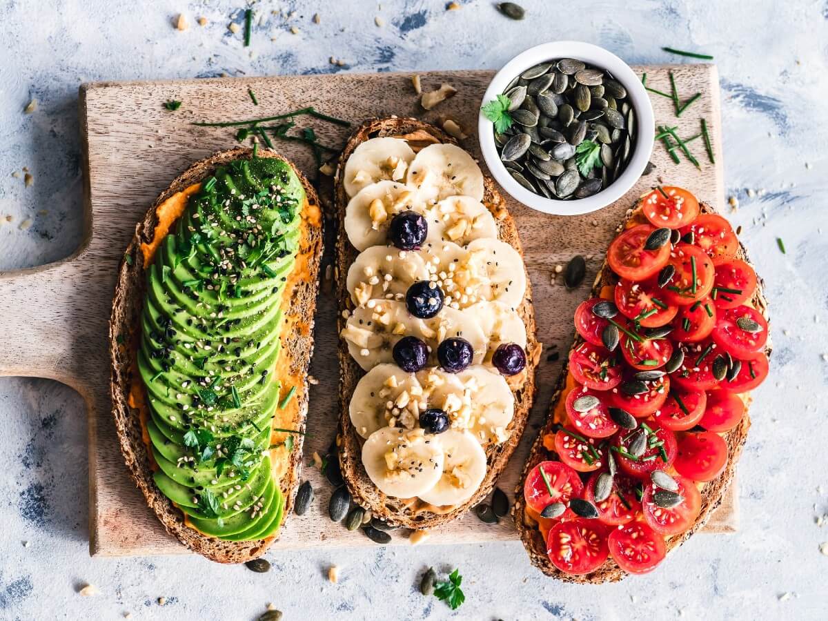 vegetarian plate of avacados, bananas, tomatoes and nuts