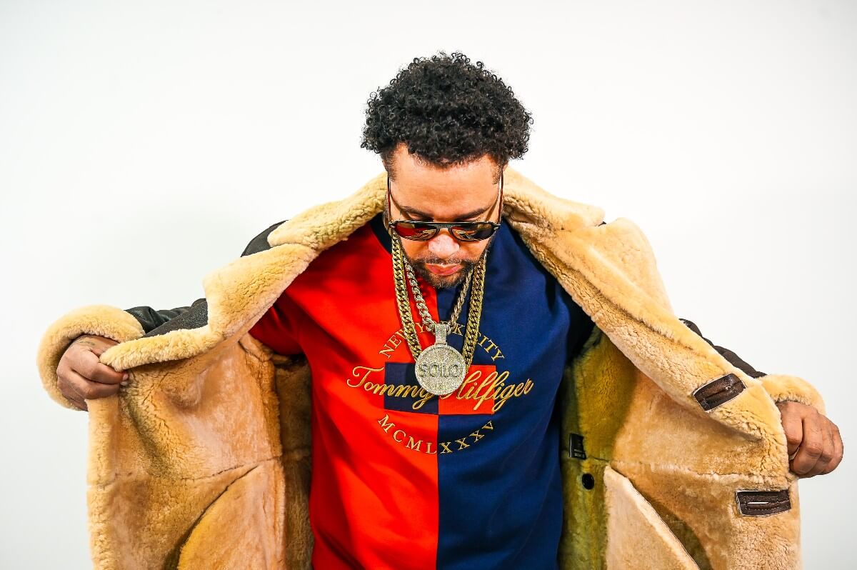 black man in brown winter jacket and red and blue Tommy Hilfilger sweatshirt