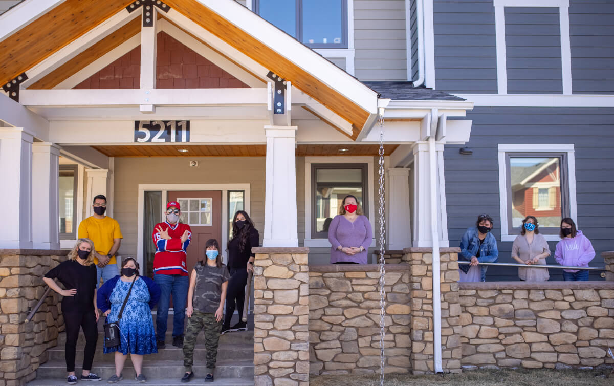 people standing in fornt of a house at creative options regina