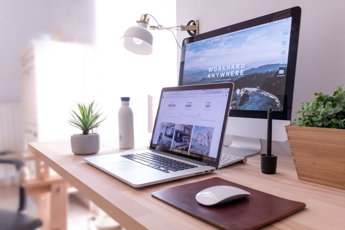 laptop, monitor and plants in a home office after covid 19