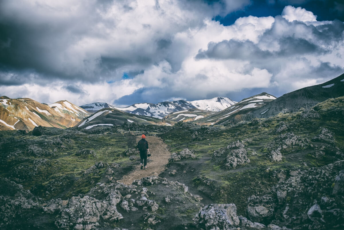 person hiking in the mountains as a way of green travel