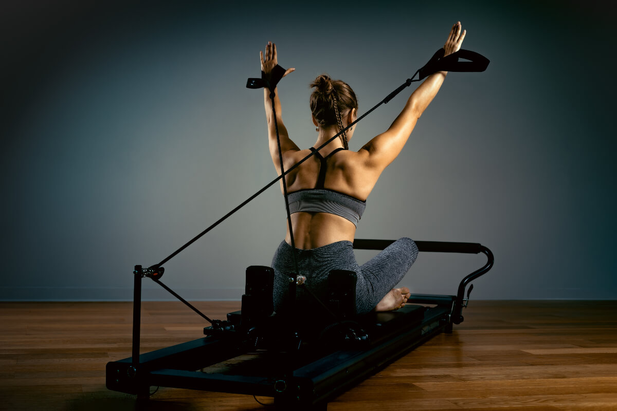 a woman on a machine practicing reformer pilates