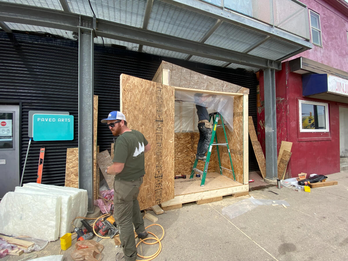 two workers constructing Saskatoon's community fridge