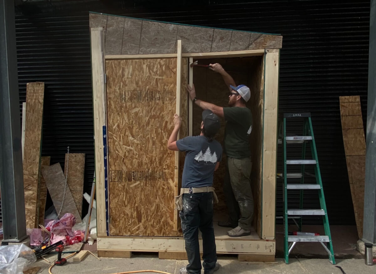 two men building Saskatoon's community fridge