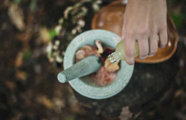 mixing green beauty products in a grey mortar and pestle