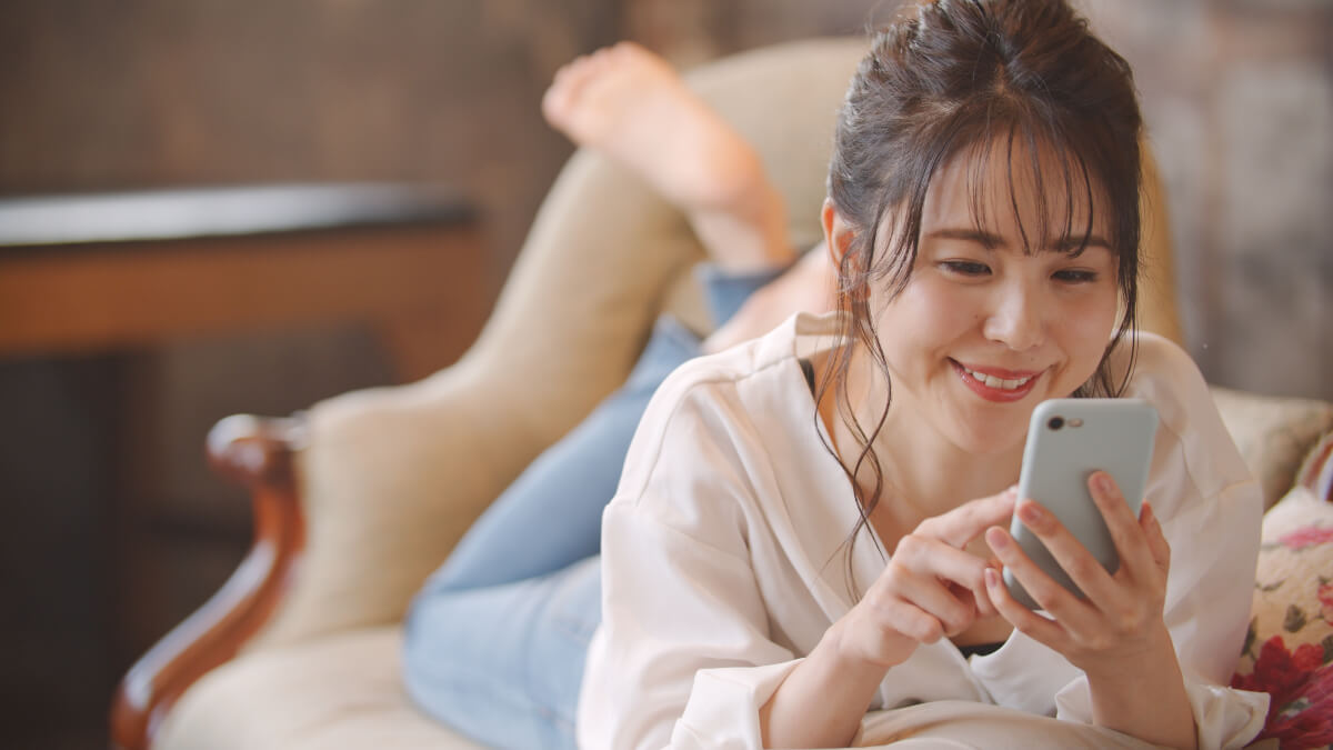 Woman smiling and using her smartphone to navigate financial milestones 