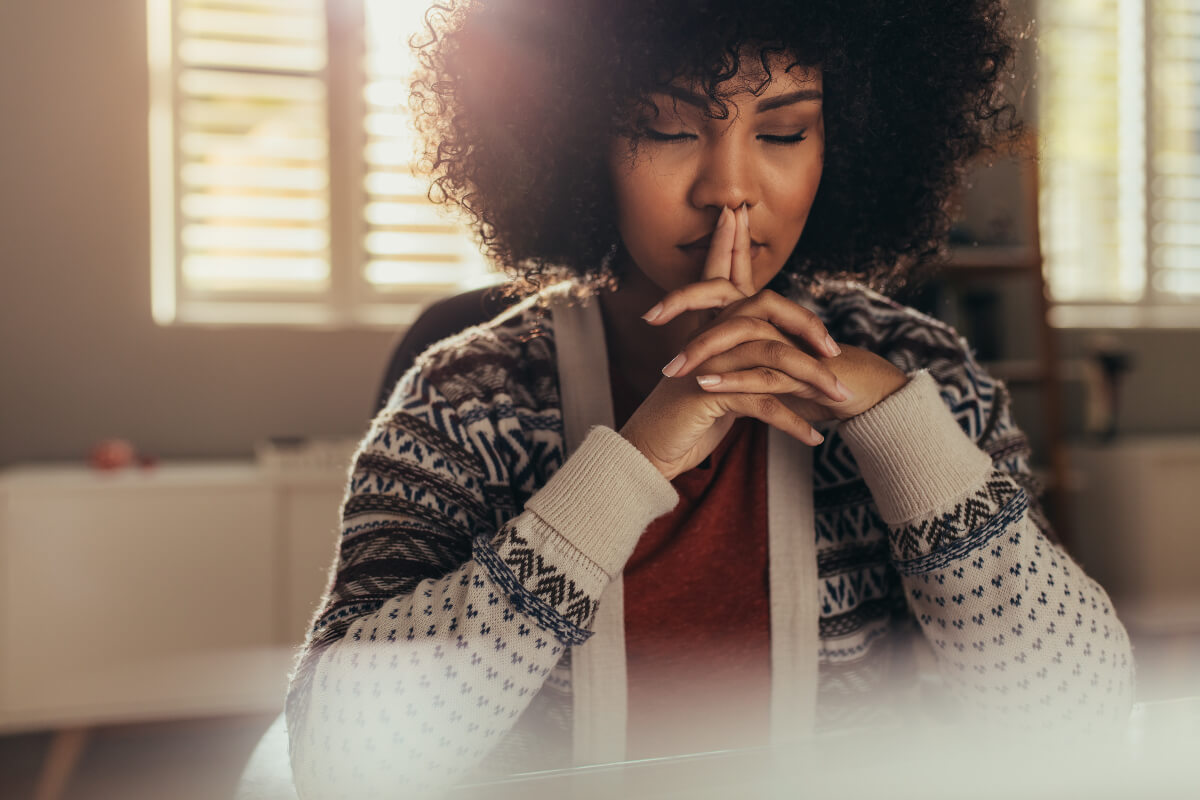 Woman sitting with her eyes closed practicing mindfulness