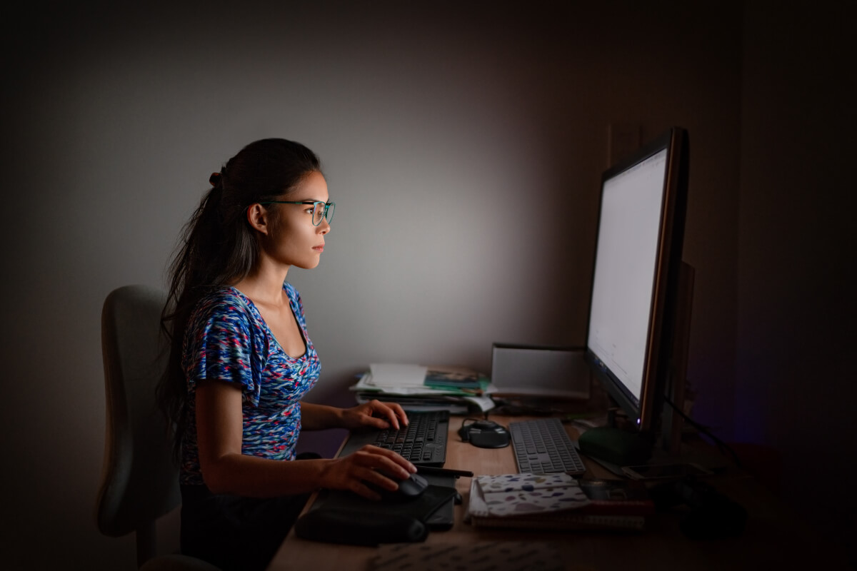 Woman sitting at her desk working on the computer looking determined 