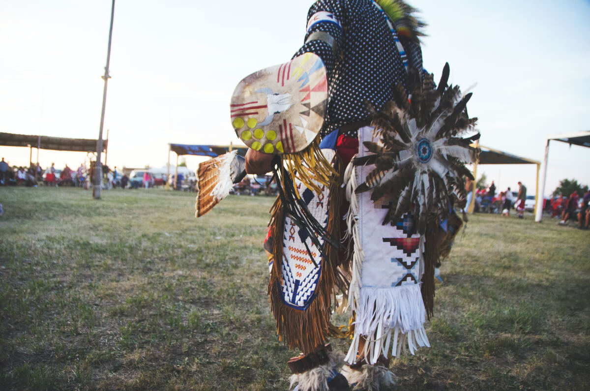 an indigenous person dressed in traditional attire at a pow wow celebrating Indigenous Peoples’ Day 2021