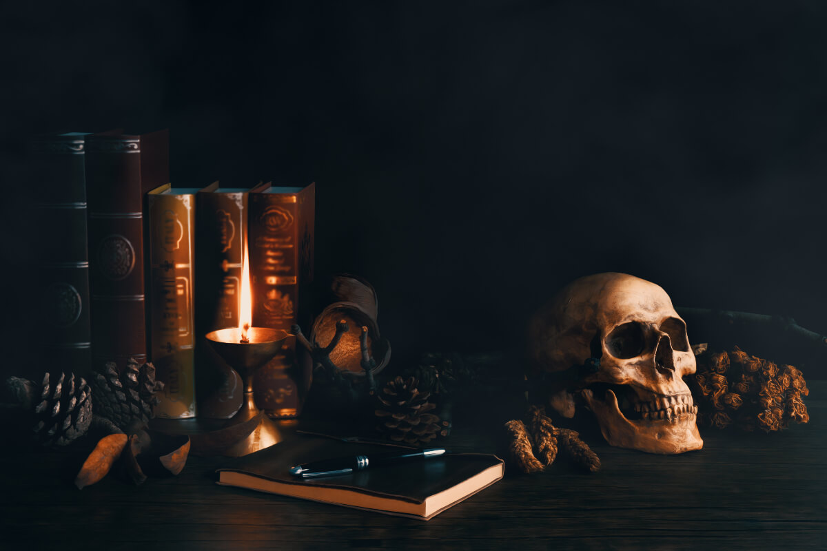 Scary, dark setting with books, candles, and a skull