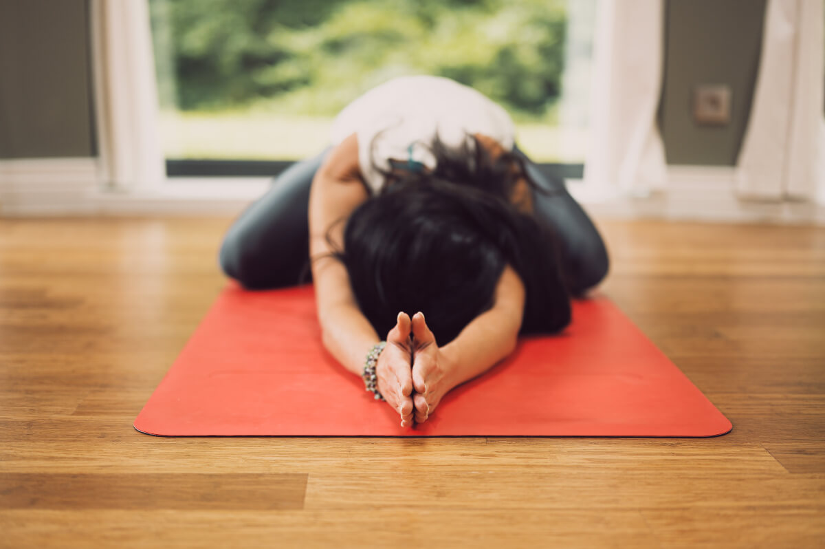 A woman practices yoga in a serene room. She clearly cares about wellness. 