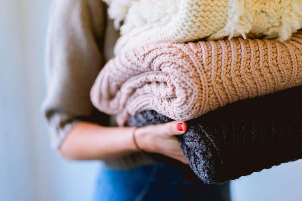 Person carrying folded laundry. 