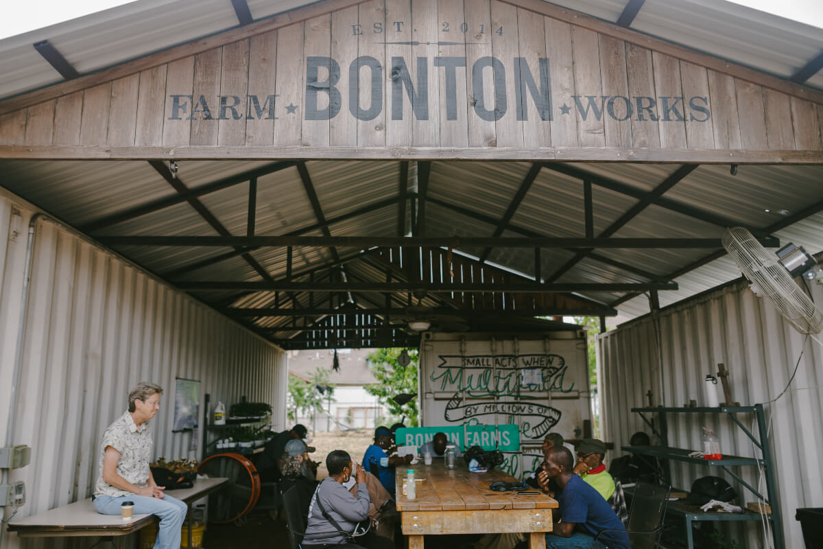 People gathered at the table at Bonton Farms. 