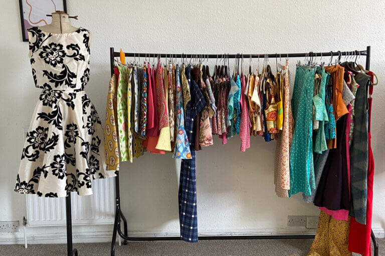 Emperor's Old Clothes, an ethical clothing brand, shows a rack of their colorful clothing.