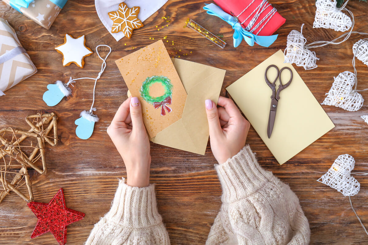 Hands making a homemade holiday card