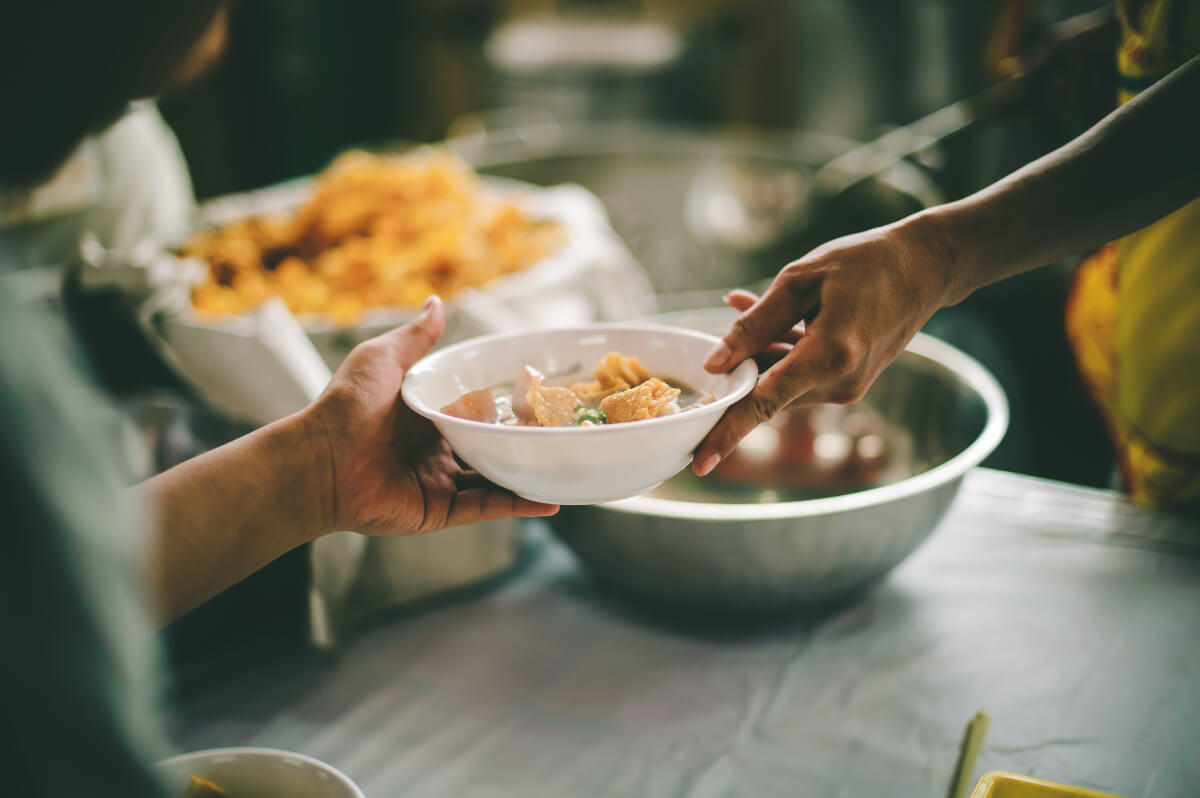 Person hands someone a bowl of soup. 