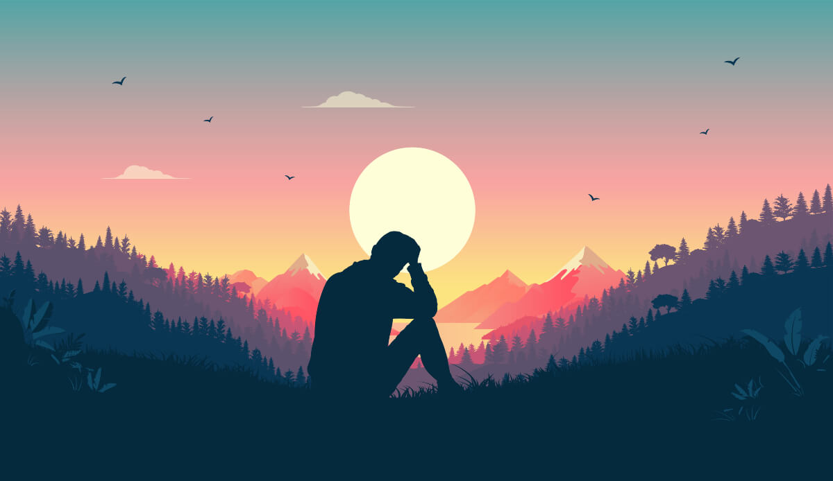 A silhouette of a man sitting and looking at the view of mountains. He is probably thinking about Movember. 