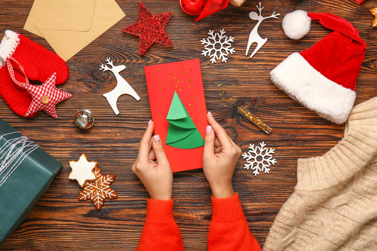 Hands holding a homemade Christmas card - one way to pay it forward. 