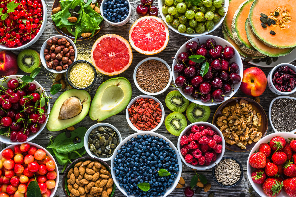 Table full of bowls of fresh, beautiful produce. Planning ahead before buying these beauties can help you reduce a ton of food waste. 